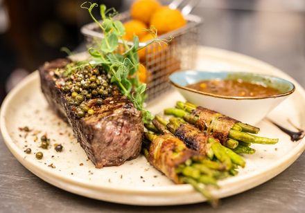 Bord met vlees, bonen in spek, saus en bijgerecht