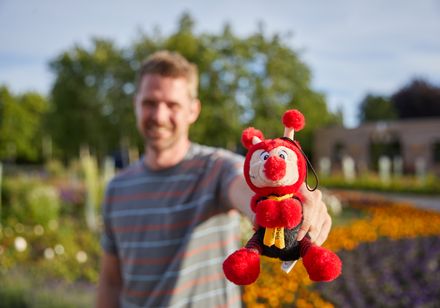 Man houdt knuffel voor de camera