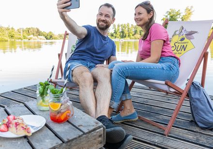 Twee personen maken een selfie in ligstoelen
