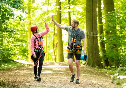Twee personen in klimpark geven elkaar een high five