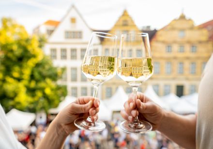 Wijnmarkt: twee handen houden wijnglazen vast