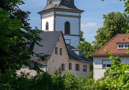 kerktoren, met groen gebladerte op de voorgrond