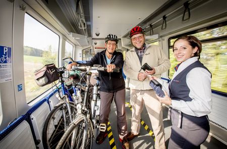 Fietser met conducteur op de trein
