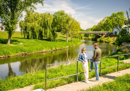Twee mensen bij een balustrade in een groen park
