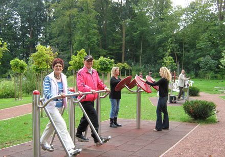 Mensen sporten op toestellen in de Tuin der Generaties