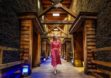 Vrouw in rode jurk loopt door gradierwerk