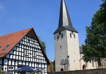 Kerkentoren naast een vakwerkhuis
