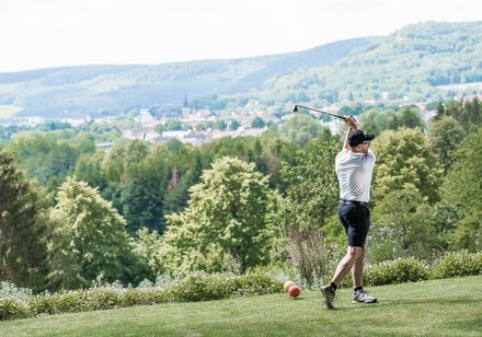 Man speelt golf met uitzicht op de groene natuur
