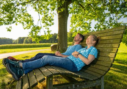 Twee mensen liggen te ontspannen op een ligstoel in de natuur