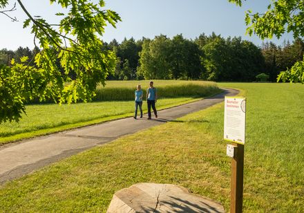 Twee mensen wandelen over een educatief bospad