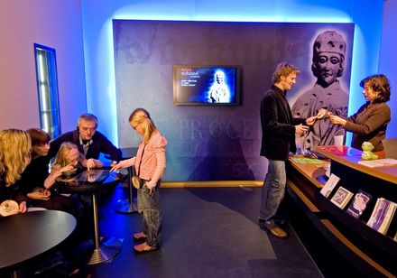 Ingangszone van het Widukindmuseum met receptietafel, mensen aan een tafel links