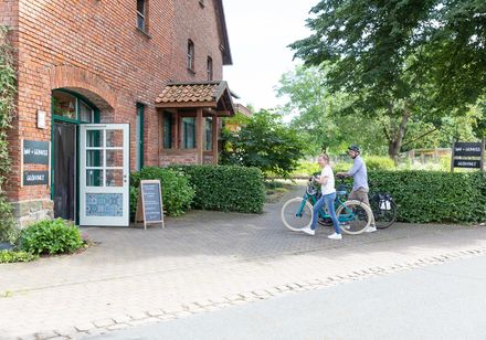 Rood bakstenen huis, open poort, twee fietsen