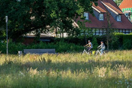 Twee fietsers rijden langs een weide