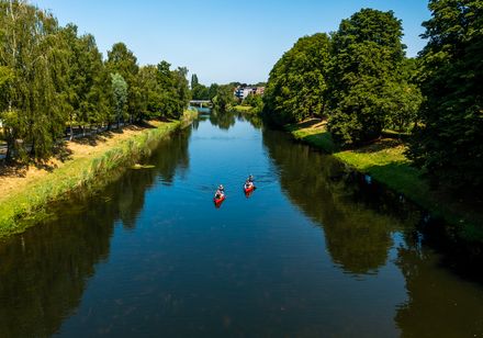 Twee personen peddelen in een rode kano op de rivier Werre