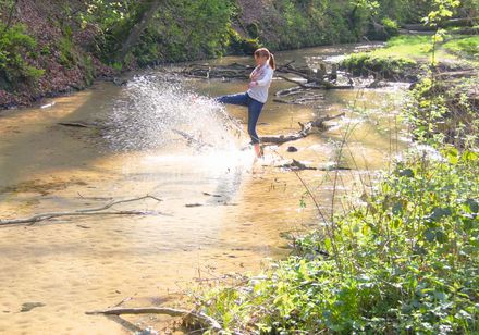 Frau spritzt Wasser aus der Ems in die Luft