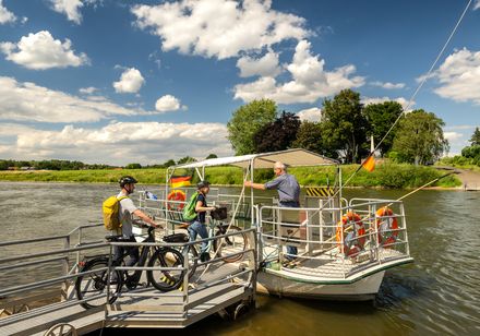 Mensen met fietsen stappen aan boord van de Weser-veerboot bij Kalletal