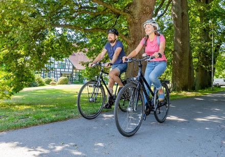 Twee fietsers met bomen op de achtergrond